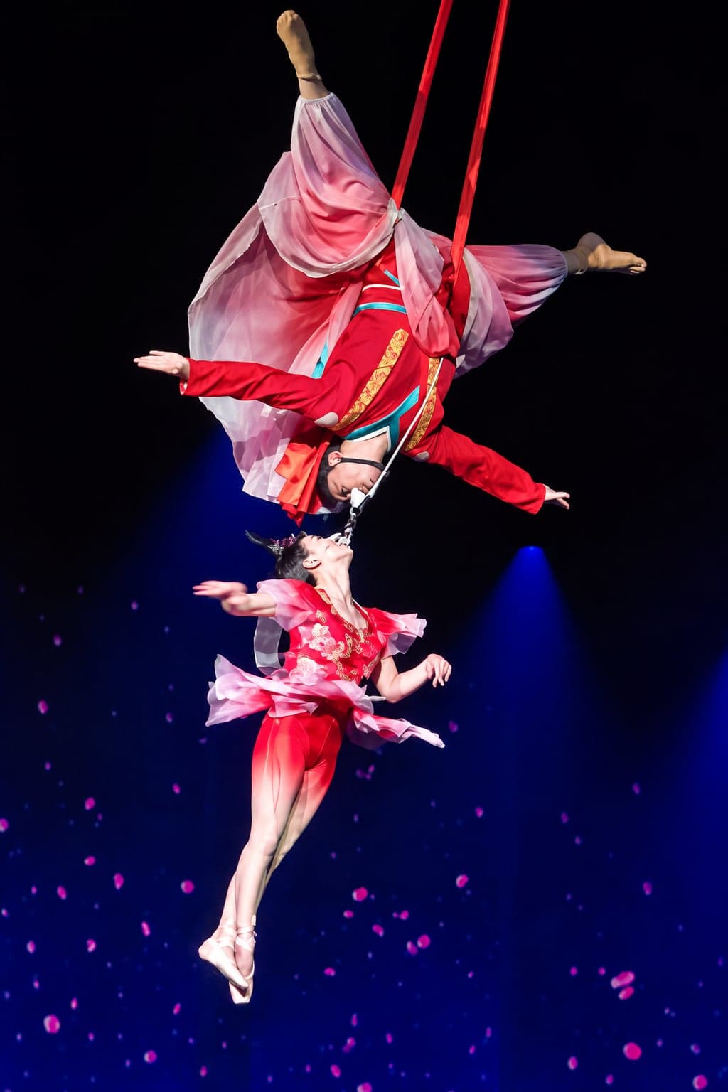 A Beijing acrobatics performance at the Red Theatre, a performer balanced on a stack of chairs under stage lights