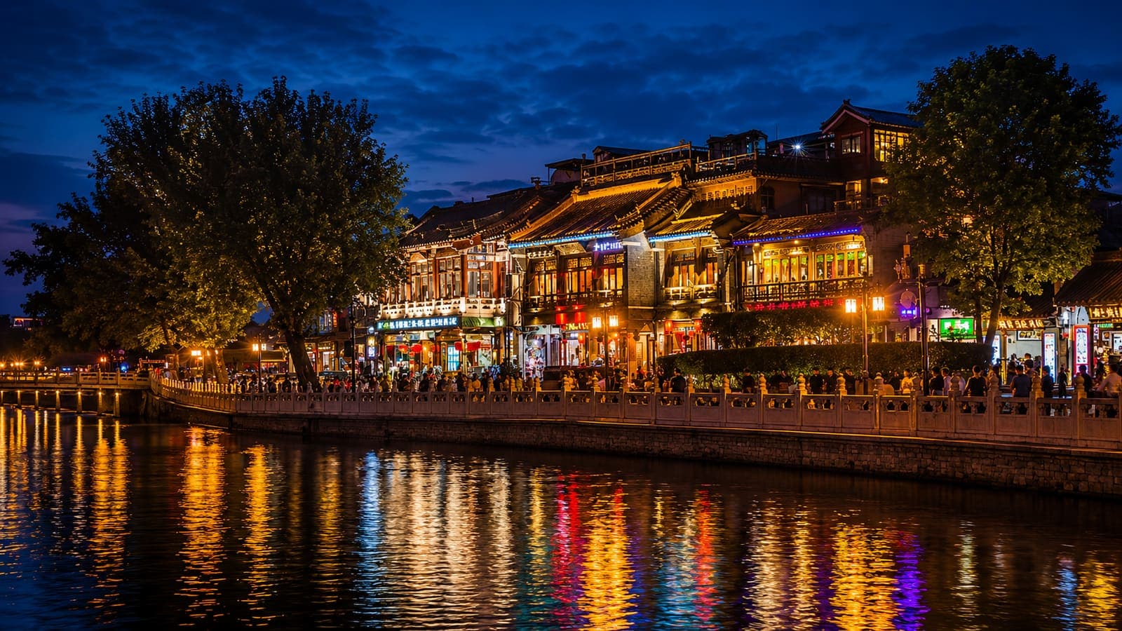 Houhai Lake at Shichahai, Beijing, the Drum Tower lit at night with hutong rooftops along the shore