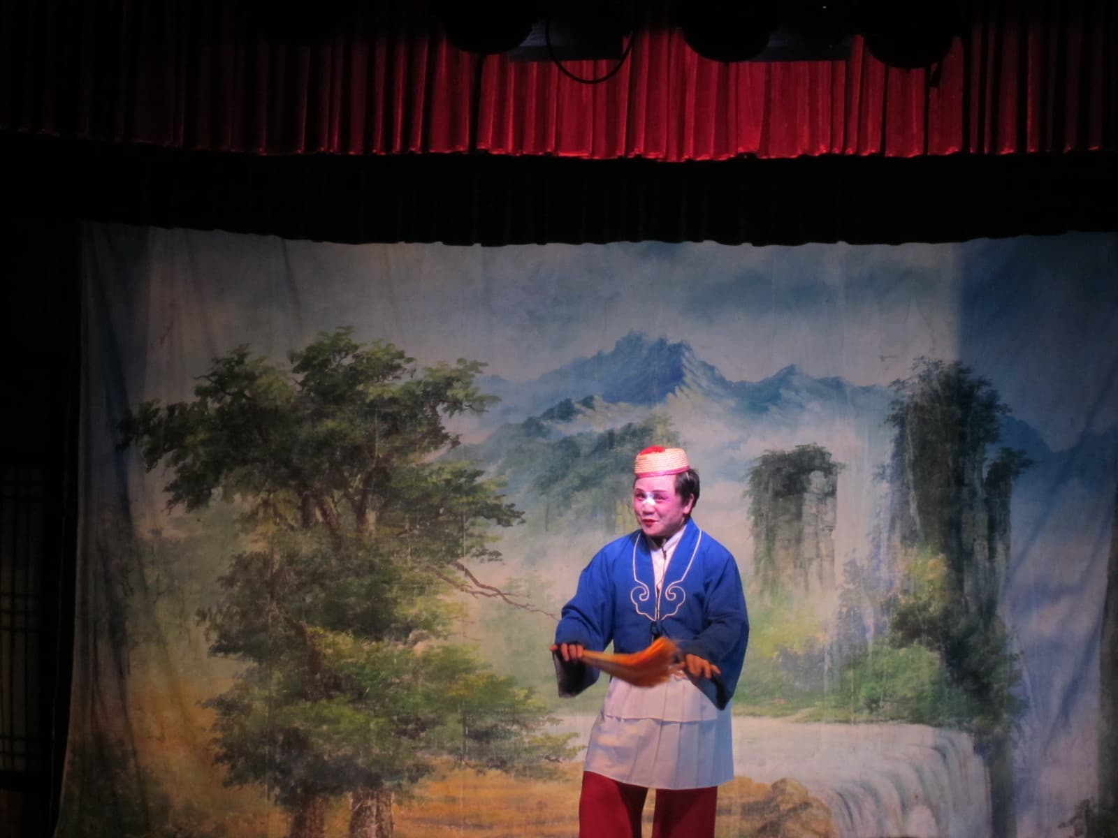 A Hunan flower-drum opera performer in painted face and embroidered robe at the Dingwangtai Intangible Cultural Heritage Centre, Changsha