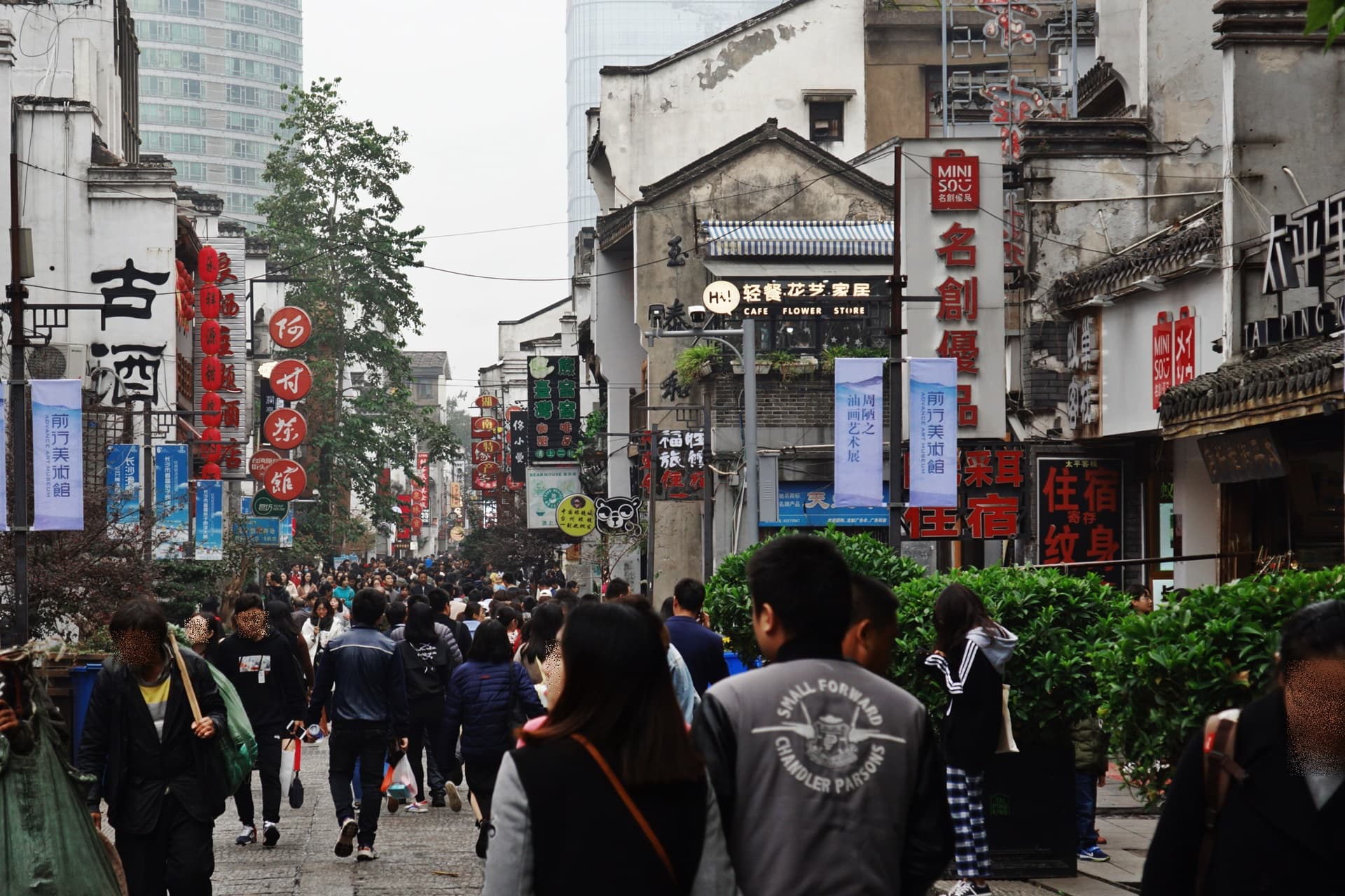 Stone-flagged Taiping Old Street at dusk, with Qing-era timber shopfronts, hanging red lanterns and the smoke of charcoal grills, Changsha