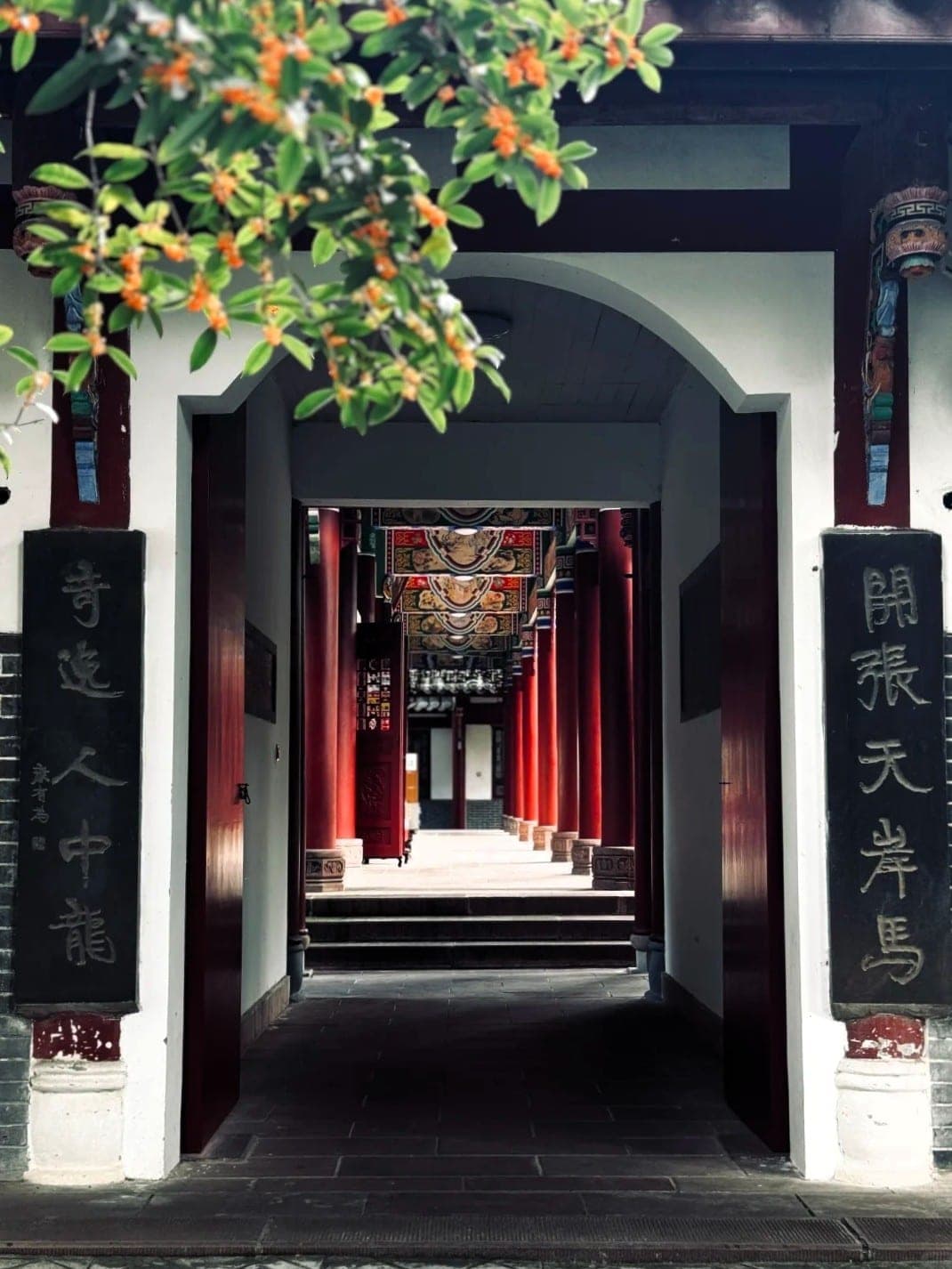 The gateway of Qingyang Palace, red pillars and painted beams beyond stone couplet tablets