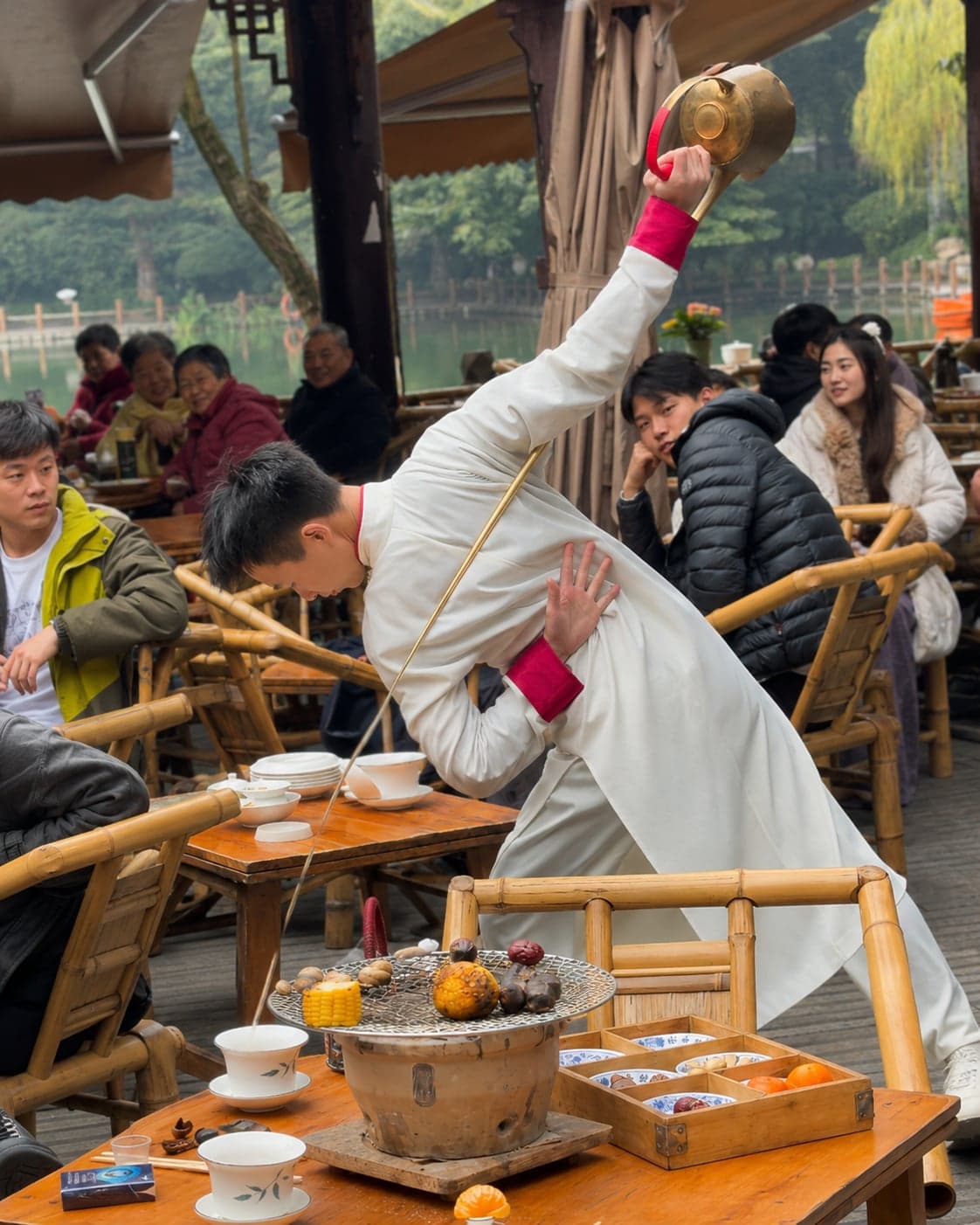 Hanging red lanterns and the traditional wooden facade of a Sichuan teahouse at night, the setting for the long-spout tea-pouring performance