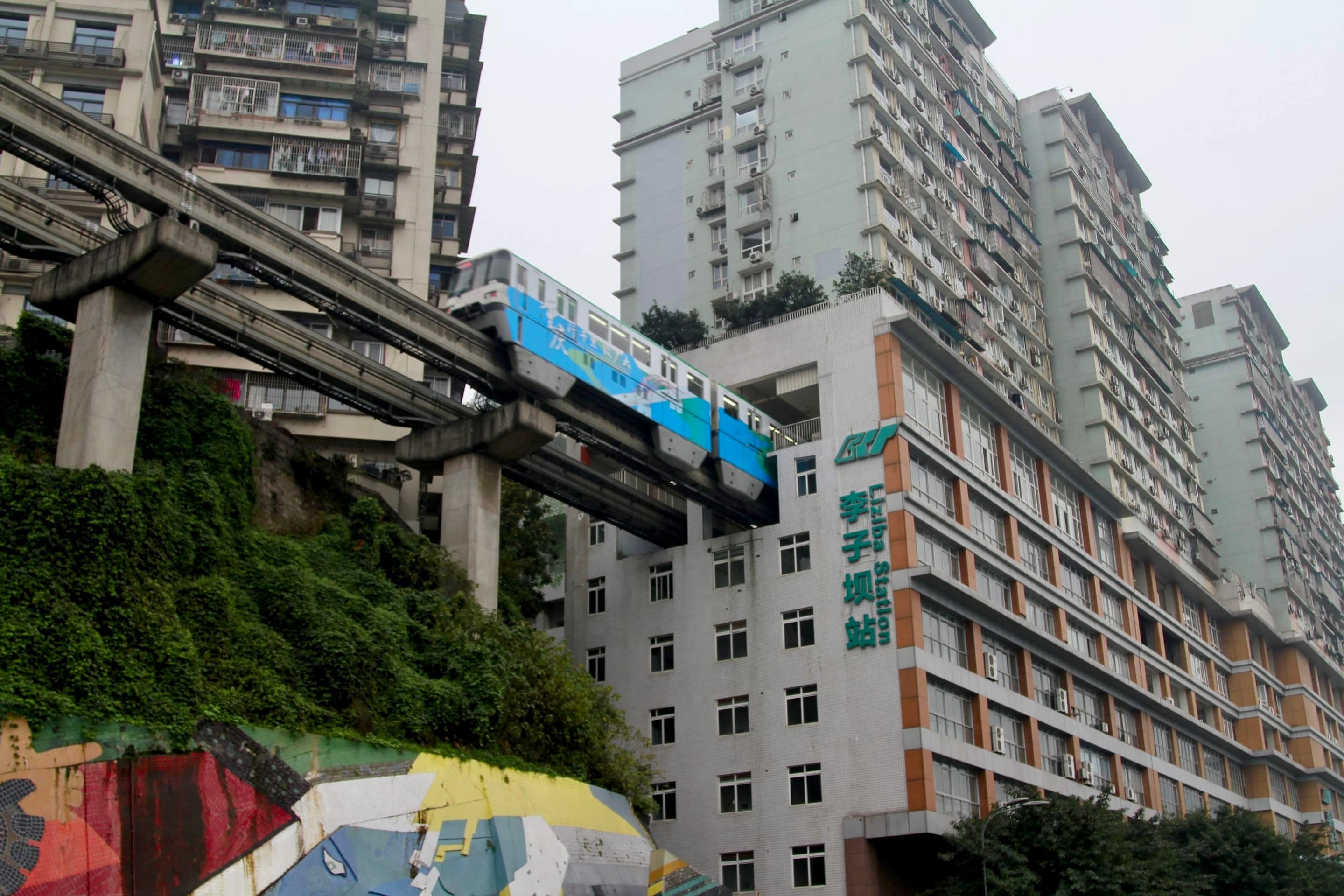 A Chongqing Line 2 monorail train passing through the middle floors of the Liziba residential block