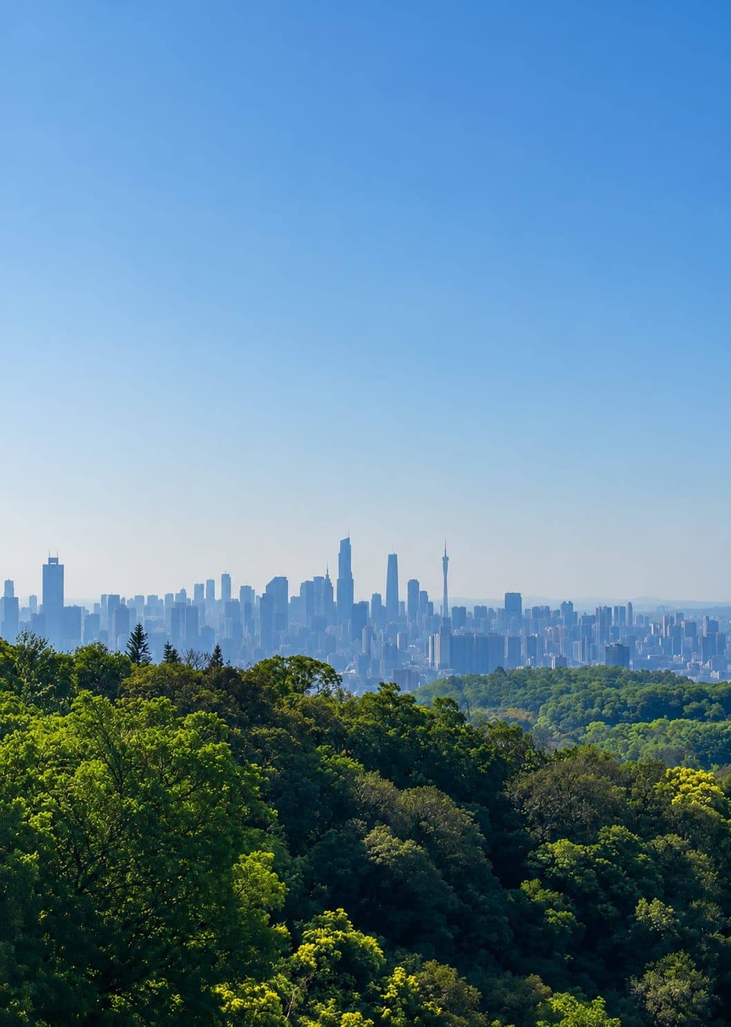 View from Baiyun Mountain over the Guangzhou skyline, Canton Tower on the horizon under cloud cover