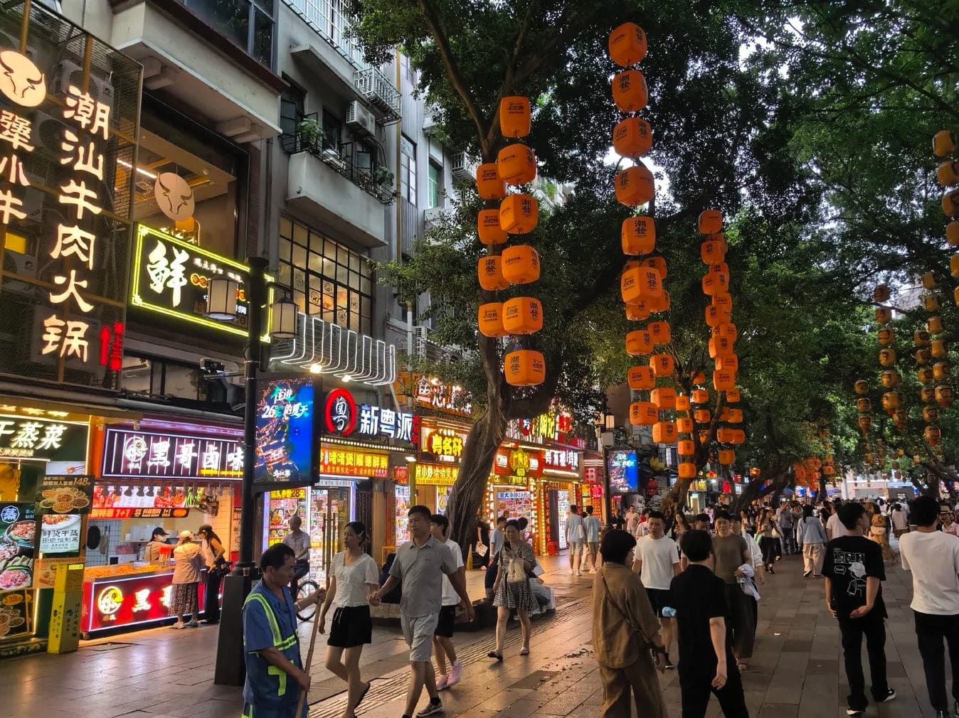 入夜后的北京路一带食肆小巷，灯笼成串悬于榕荫之间，店招次第亮起，人潮往来