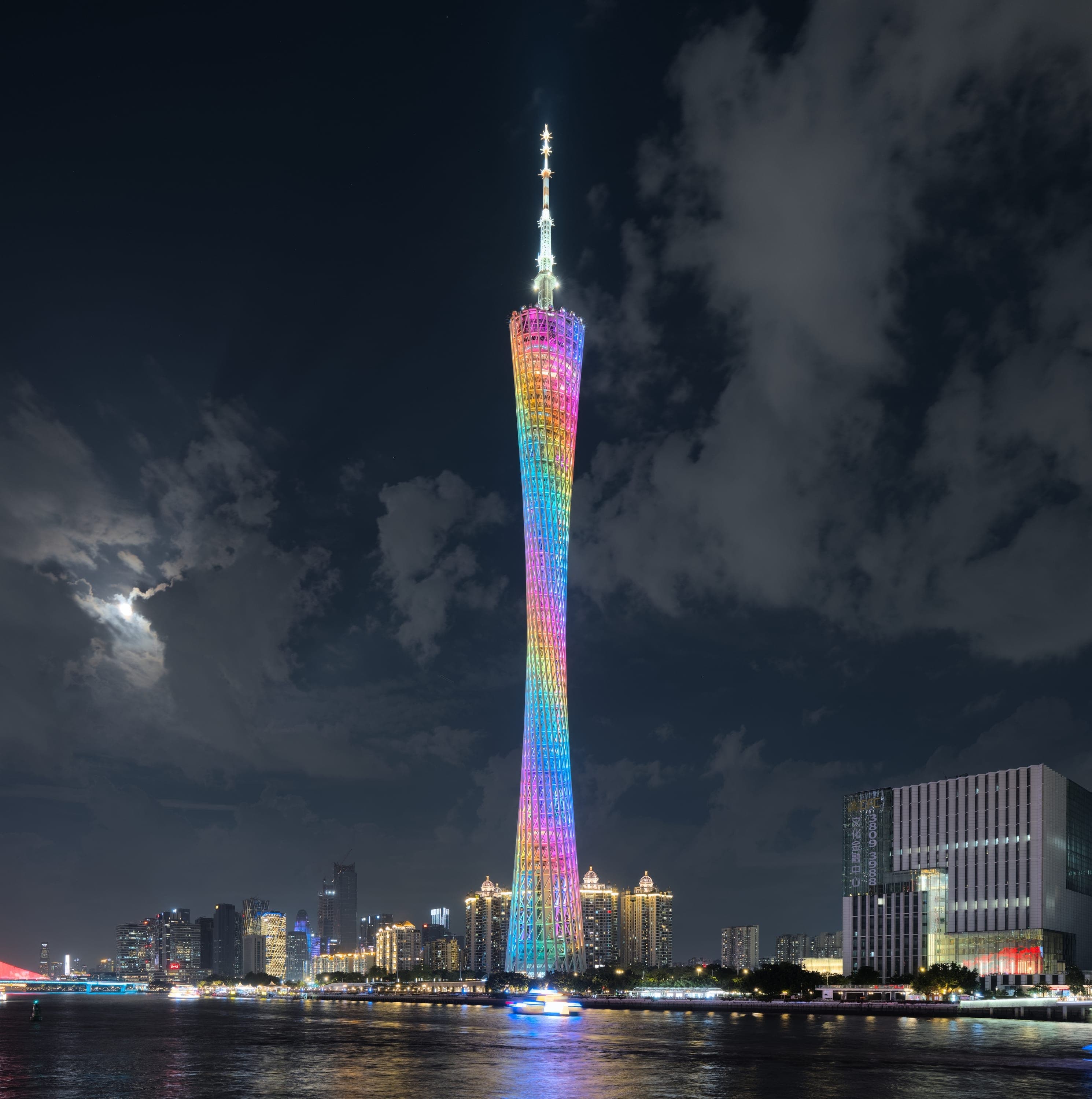 Canton Tower lit at twilight over the Pearl River, with the Zhujiang New Town skyline behind, Guangzhou