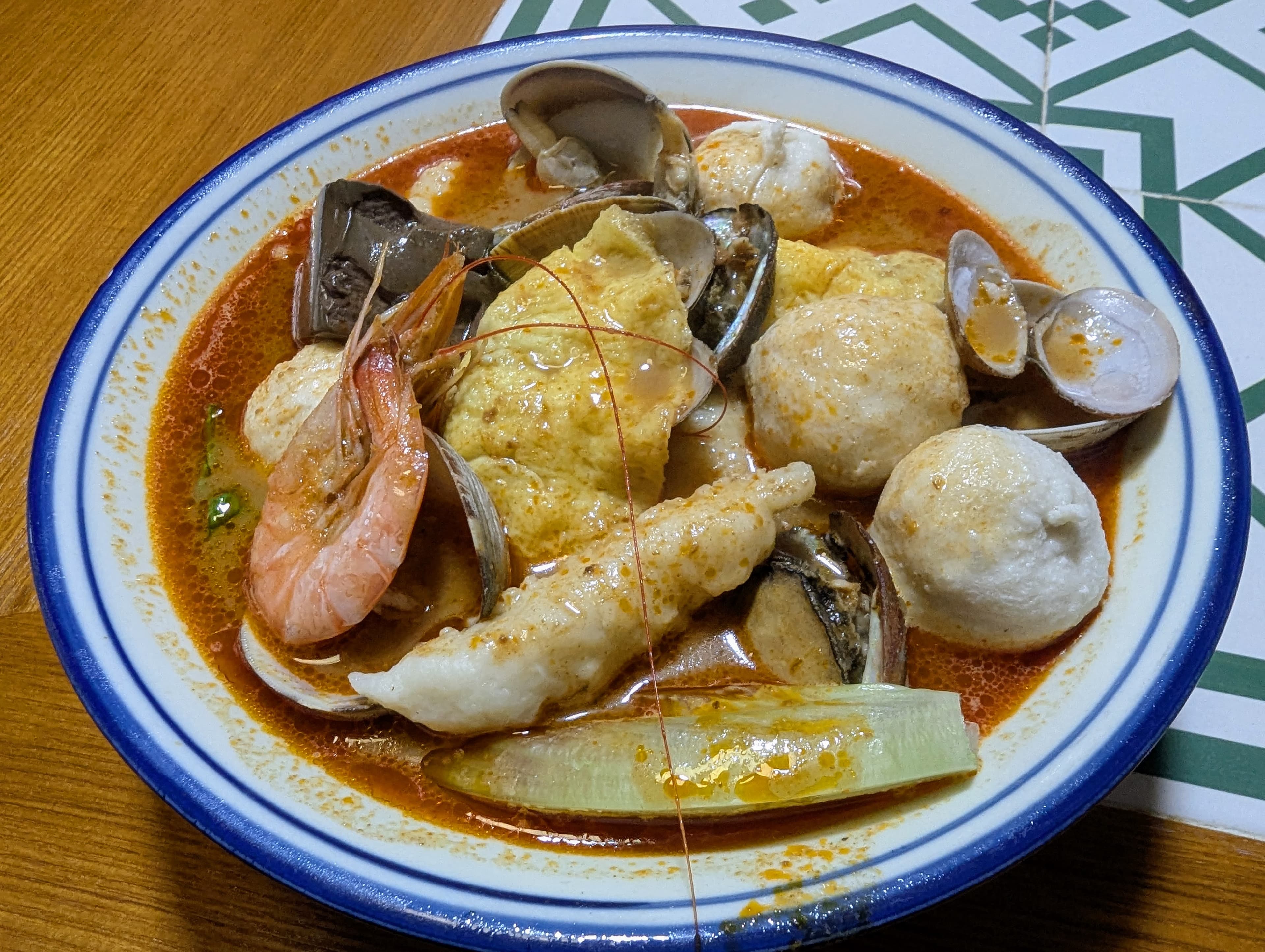A bowl of Guangzhou shacha noodles, wheat noodles in a peanut and shrimp-rich broth topped with squid and fish balls
