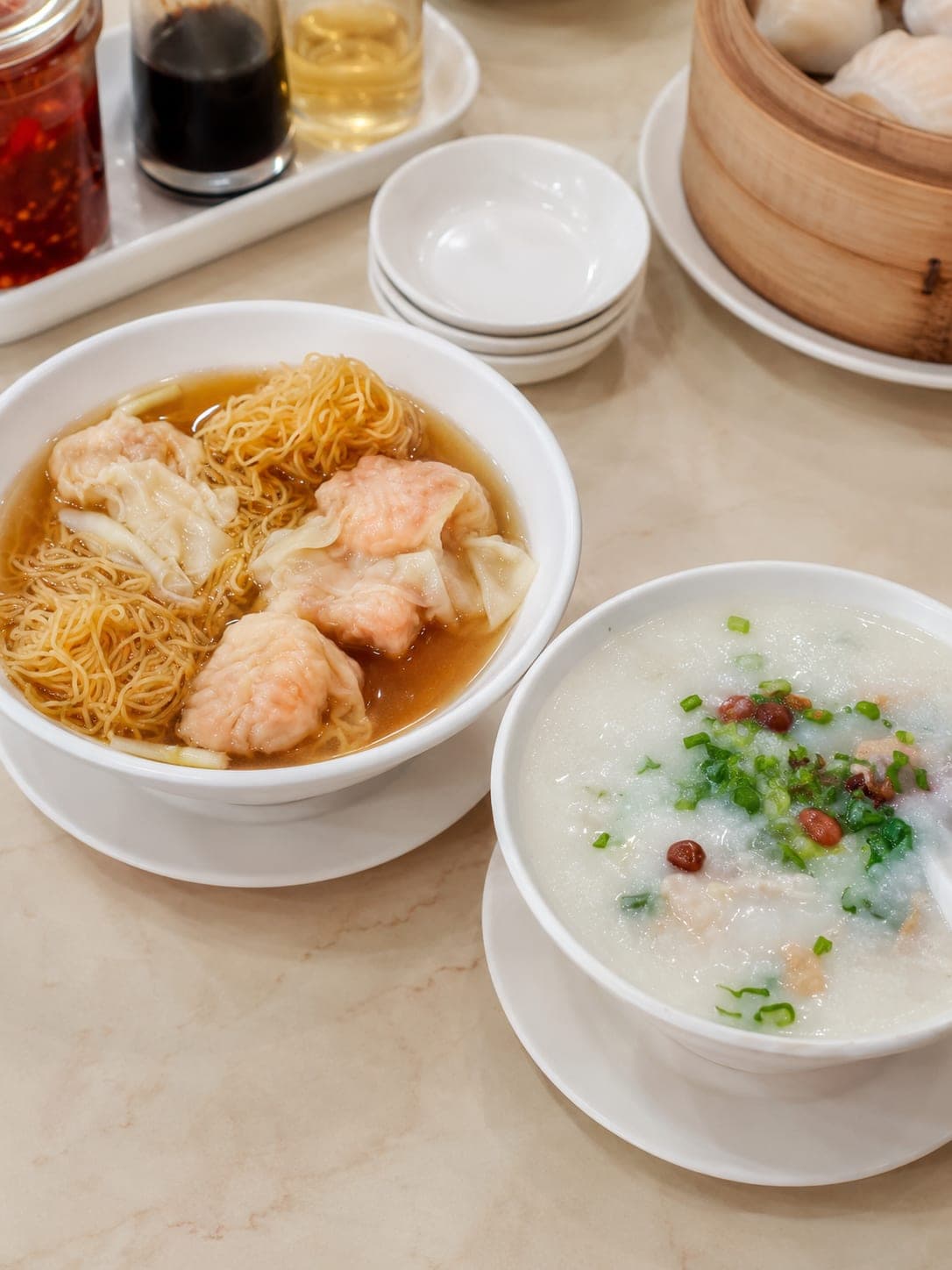 A bowl of Cantonese wonton noodles, thin lye-water noodles over prawn-and-pork wontons in clear broth, Guangzhou