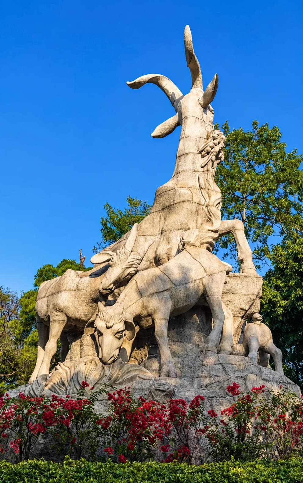 The Five Rams Statue at Yuexiu Park, bougainvillea at the plinth and the city emblem of Guangzhou