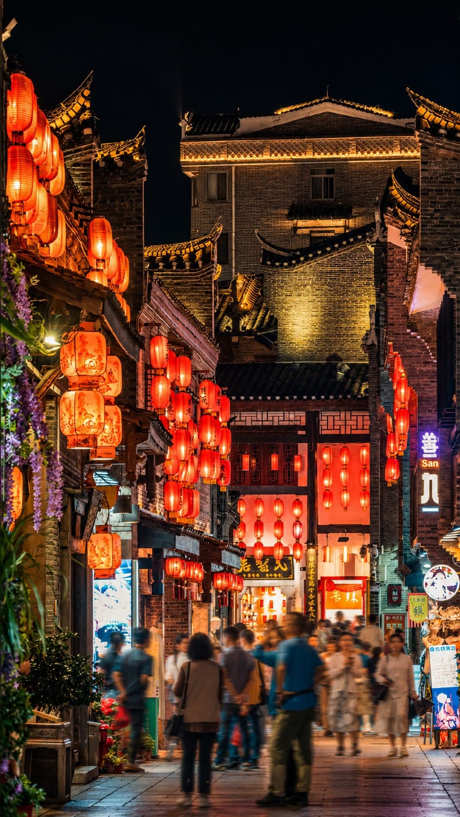 The narrow restored grey-brick lanes of Dongxi Xiang at the front of Jingjiang Princes' City, lined with snack stalls and red lanterns