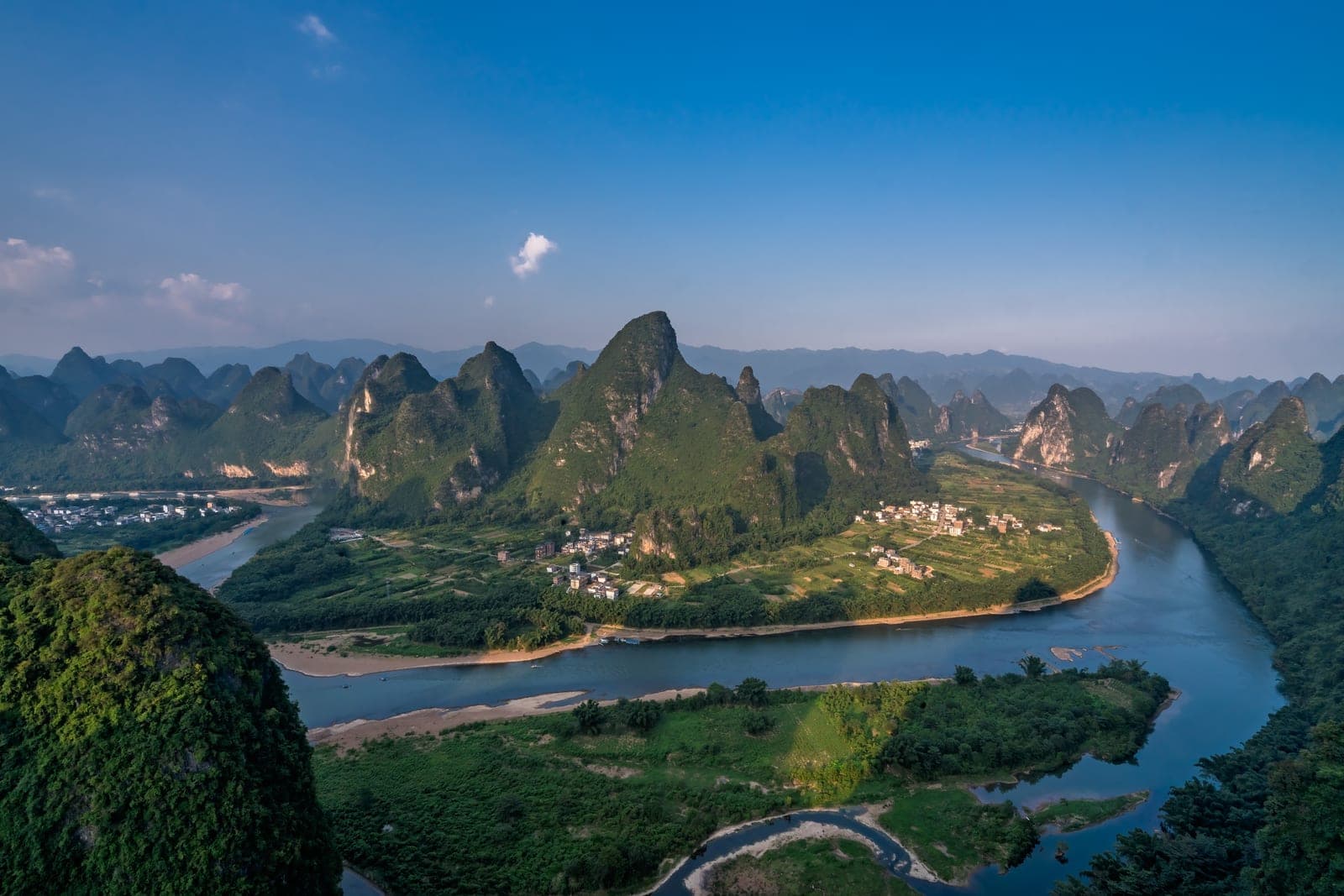 Sunrise over the 180-degree Li River bend seen from the Xianggong Hill summit, with karst peaks layered in mist