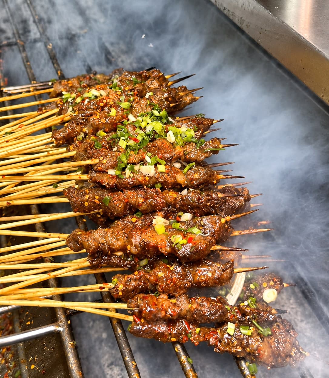 Northeast BBQ in Harbin, the city's late-night charcoal-grill ritual built around lamb skewers dusted heavily with cumin and ground chilli