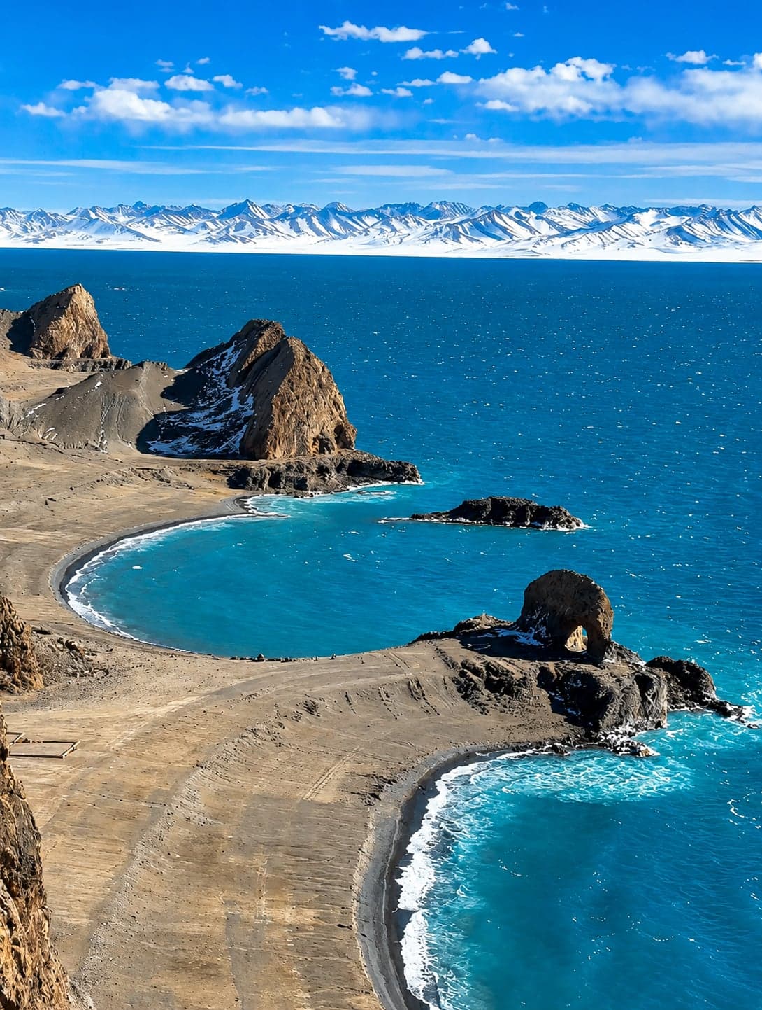 Namtso Lake in deep blue beneath the Nyenchen Tanglha range, prayer flags strung at Tashi Dor