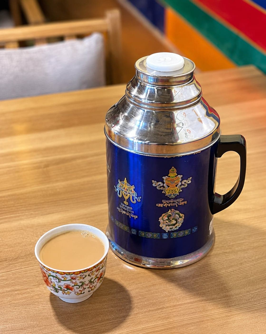 A glass tumbler of Tibetan sweet tea on a low table at a Barkhor-area teahouse, Lhasa