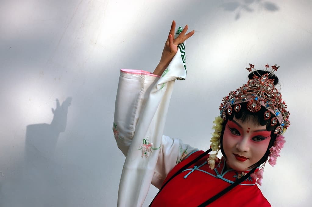 南京兰苑剧场之上一位昆曲青衣演员，浅蓝罗衫与凤冠齐整，前沿字幕灯发出柔光