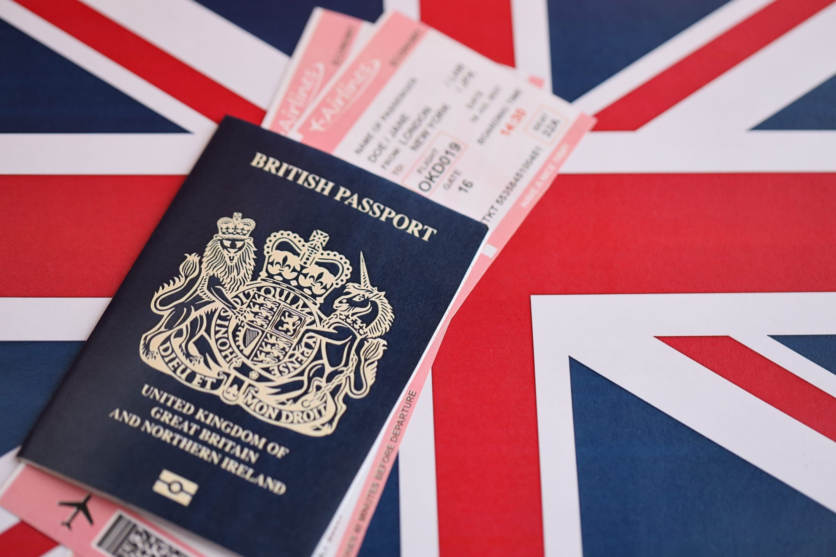 A British passport with airline tickets resting on the Union flag