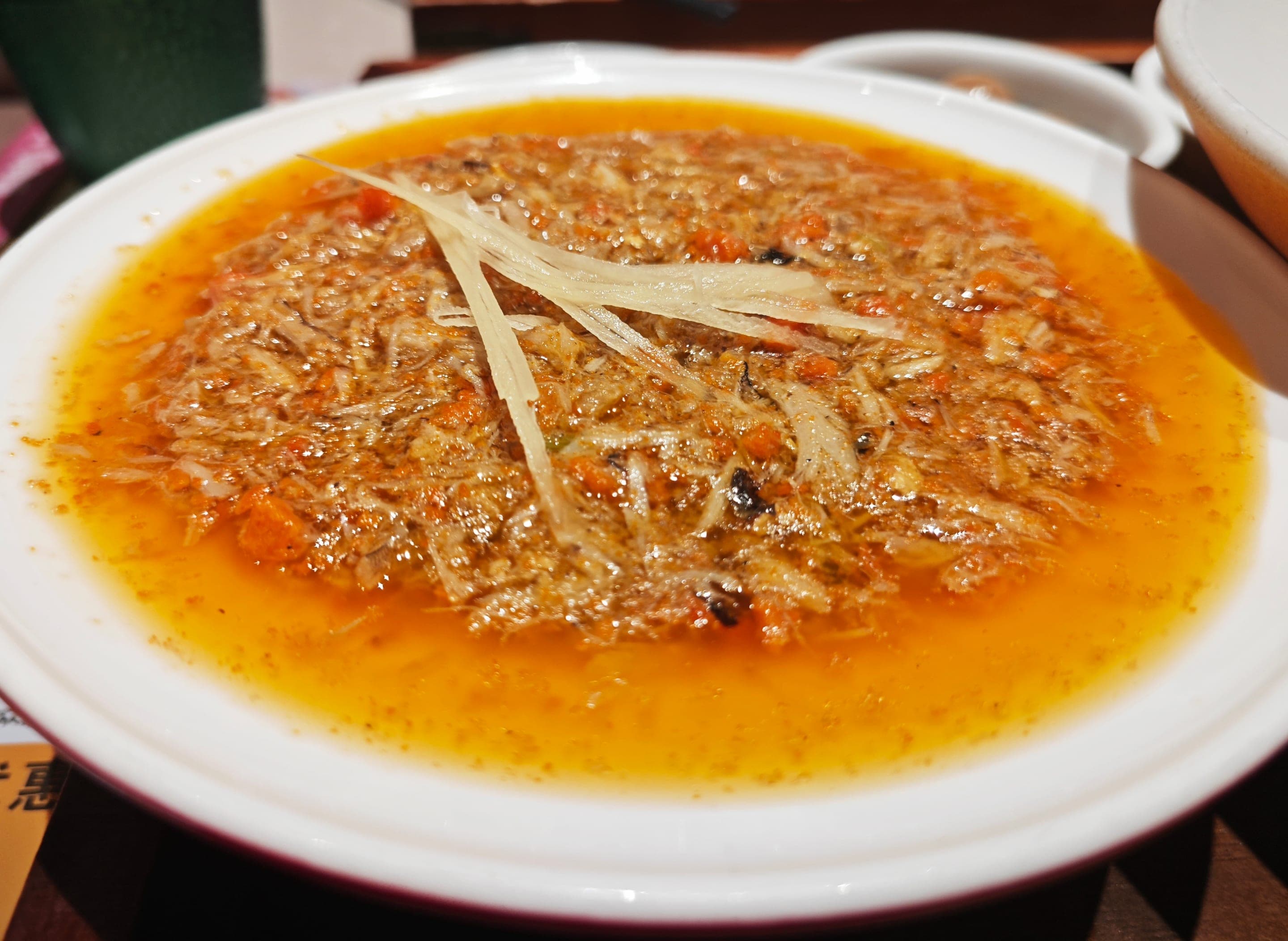 A bowl of crab roe noodles, golden hairy-crab roe stirred in scallion oil and lard coating thin white noodles, the autumn dish of the Jiangnan kitchen that Suzhou and Shanghai share