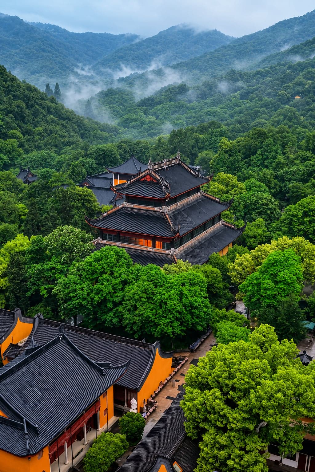 The yellow-walled halls of Lingyan Mountain Temple climbing the wooded hillside above Mudu, mist drifting through the ridges of greater Suzhou