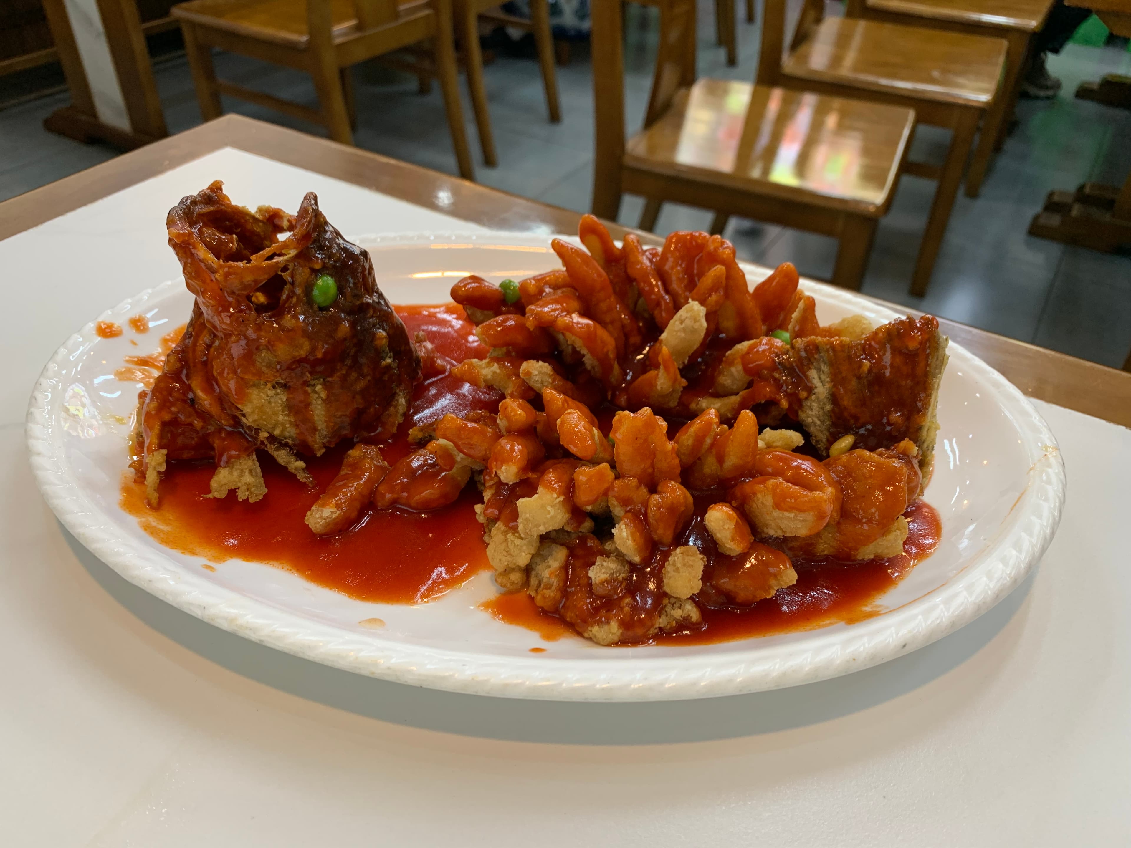 Squirrel mandarin fish, a whole fish scored and deep-fried so the fillets curl outward, dressed in amber Suzhou sweet-and-sour sauce