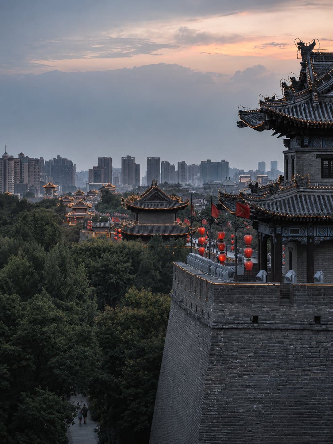 A lit Ming-dynasty watchtower on the Xi'an city wall at night, its lanterns reflected in the moat
