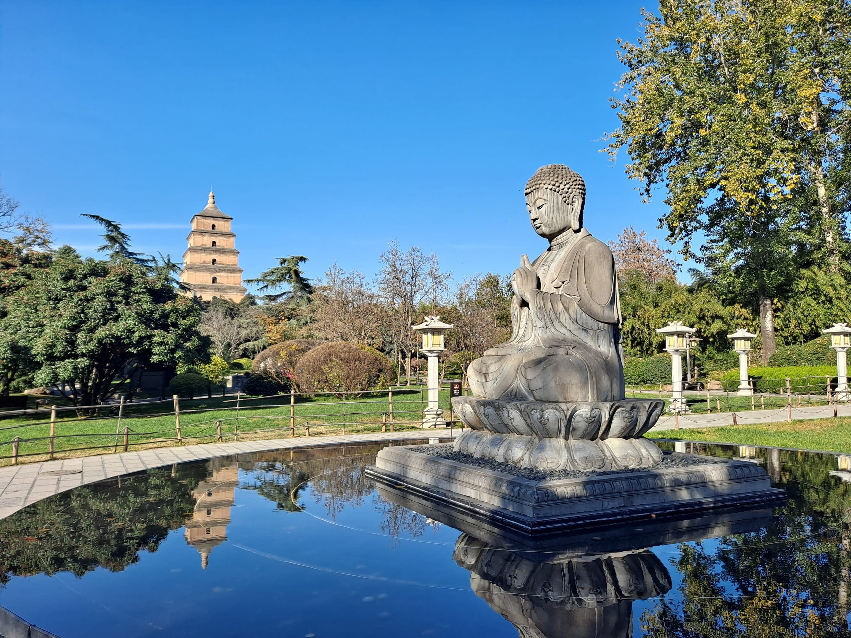 大慈恩寺遗址公园内的佛像与倒影池，远处可见大雁塔
