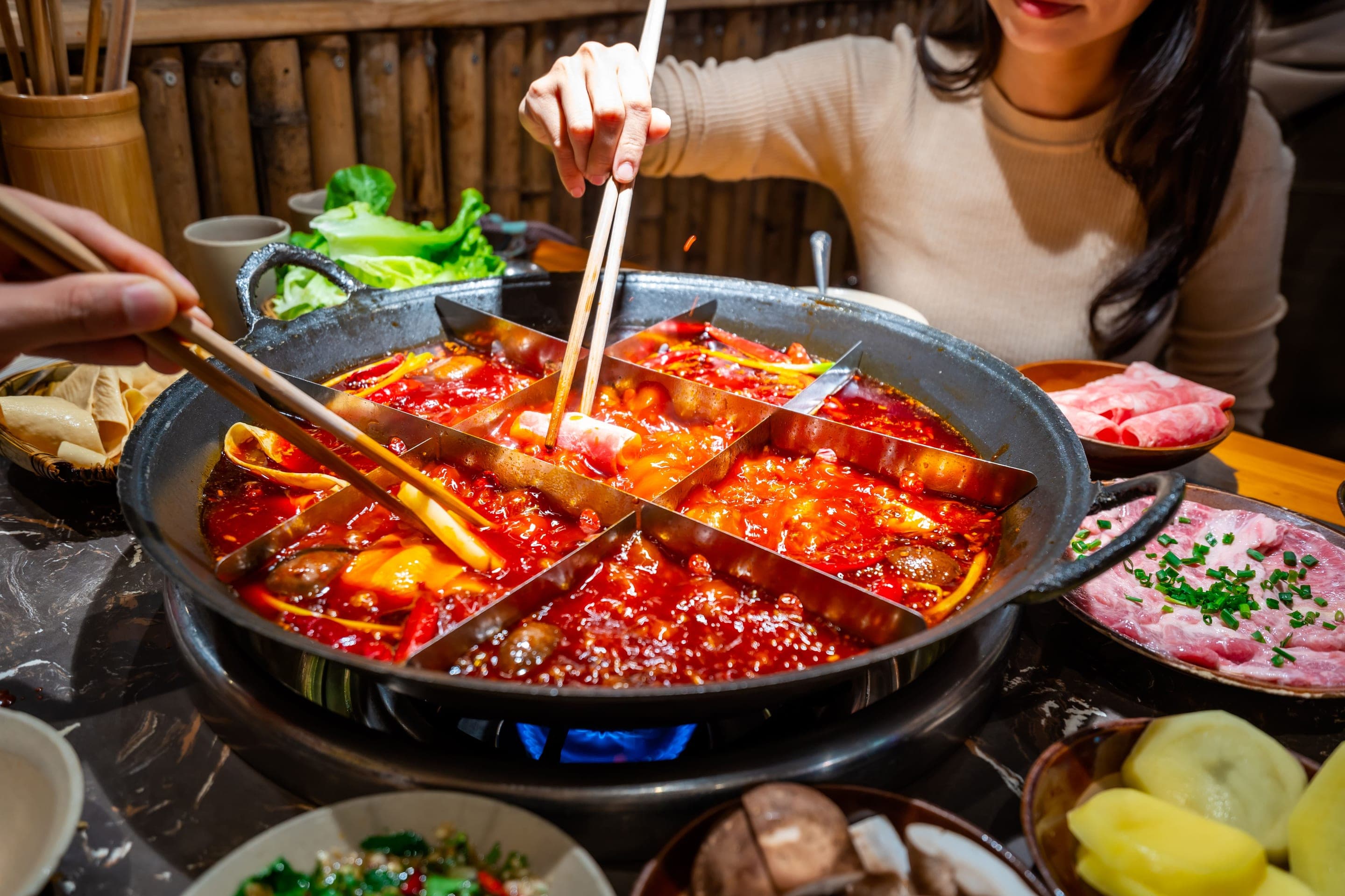 A bubbling Chongqing málà hot pot at a back-street house, broth red with chillies and Sichuan peppercorn