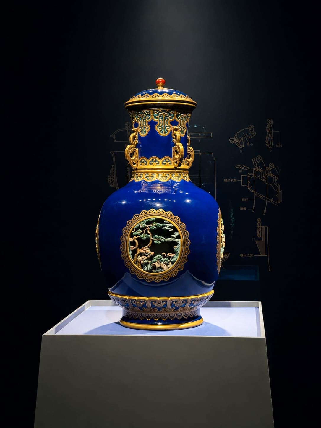 南京博物院展厅之中,一只清宫蓝地描金珐琅彩瓶立于展座之上,背后暗墙之上另有这件器物的工艺图样