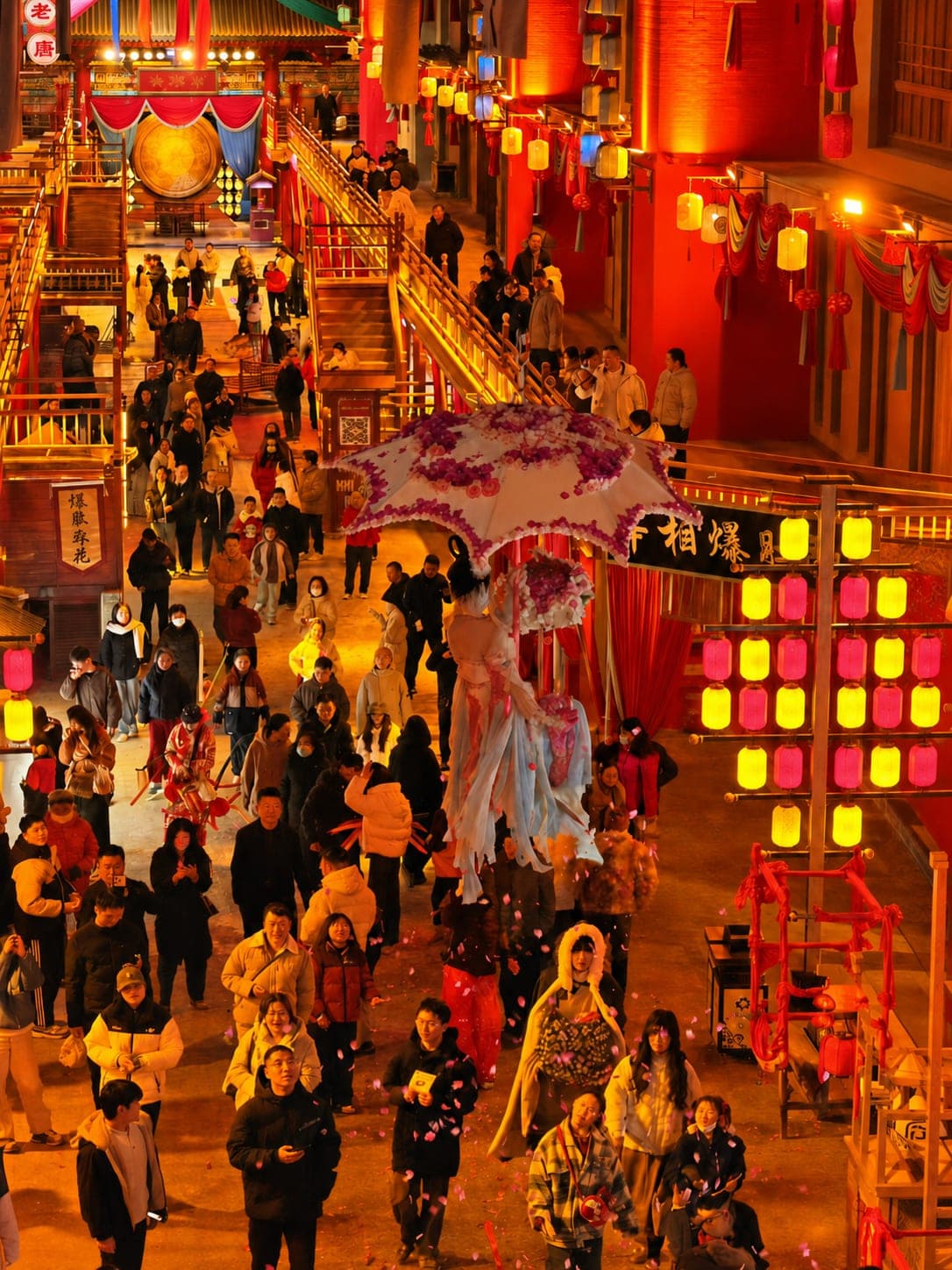 夜色下的袁家村,红灯笼映亮村巷,高跷艺人在人群间走过