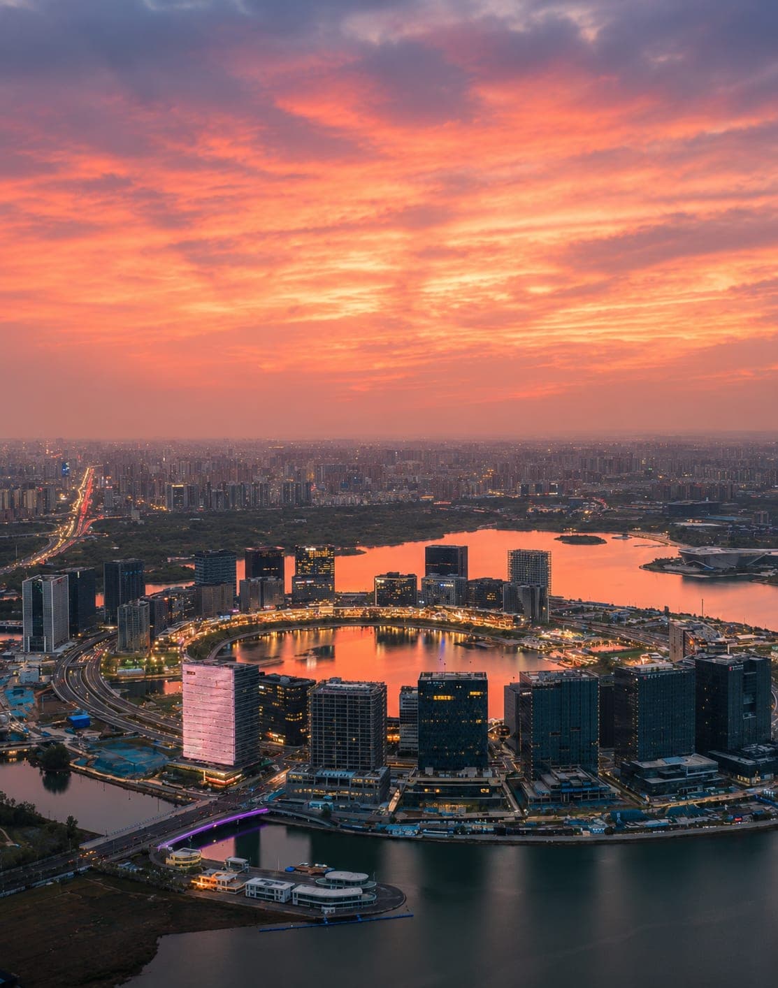 夕阳之下,龙湖金融岛俯瞰一景,四十余座塔楼依内外两圈排布于北龙湖人工湖心之上,郑州新金融区