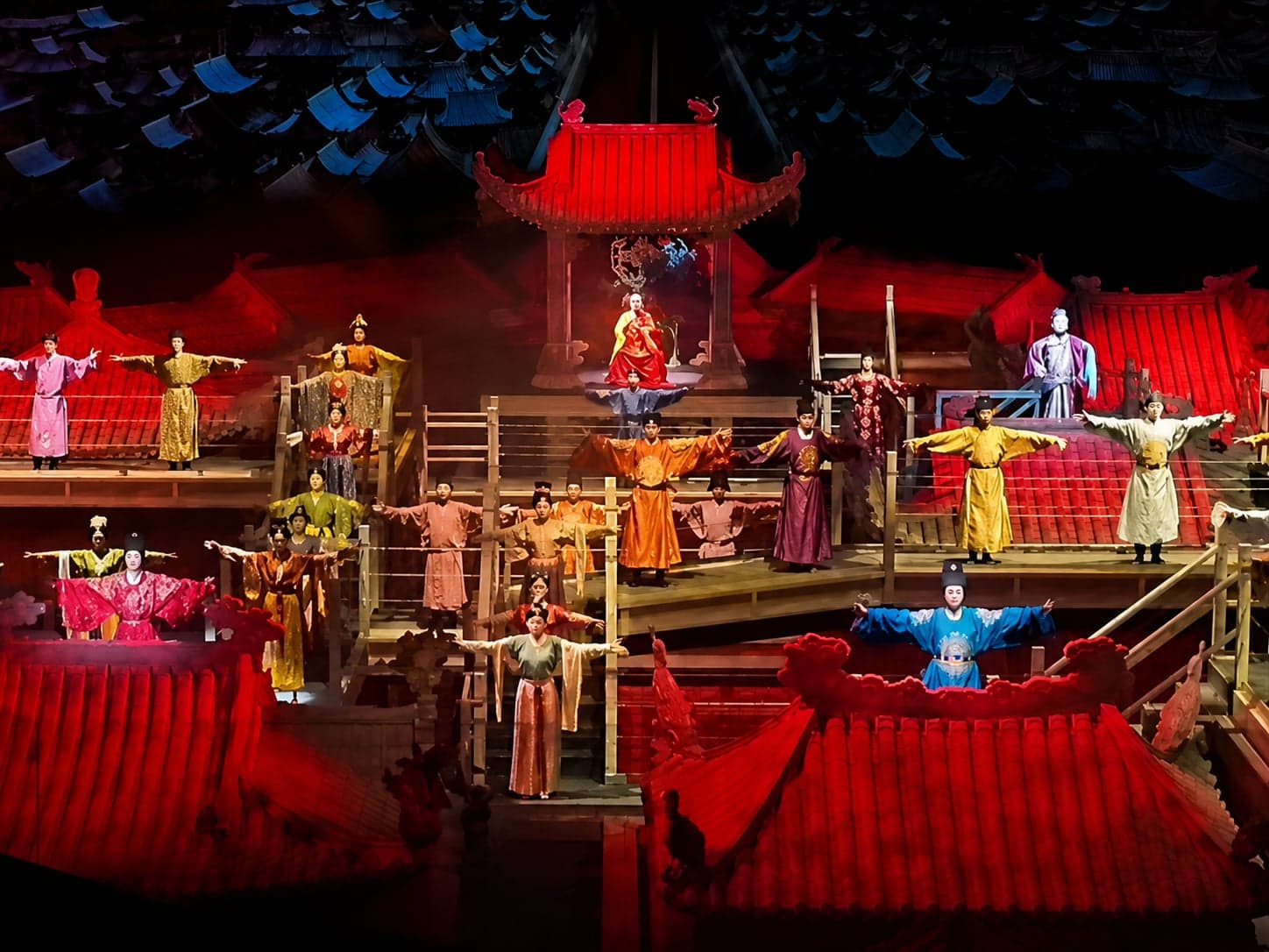 黄帝故里景区一台夜剧:演员身着各色古装,列于多层红顶宫阁之间,中央黄帝端坐高台之上