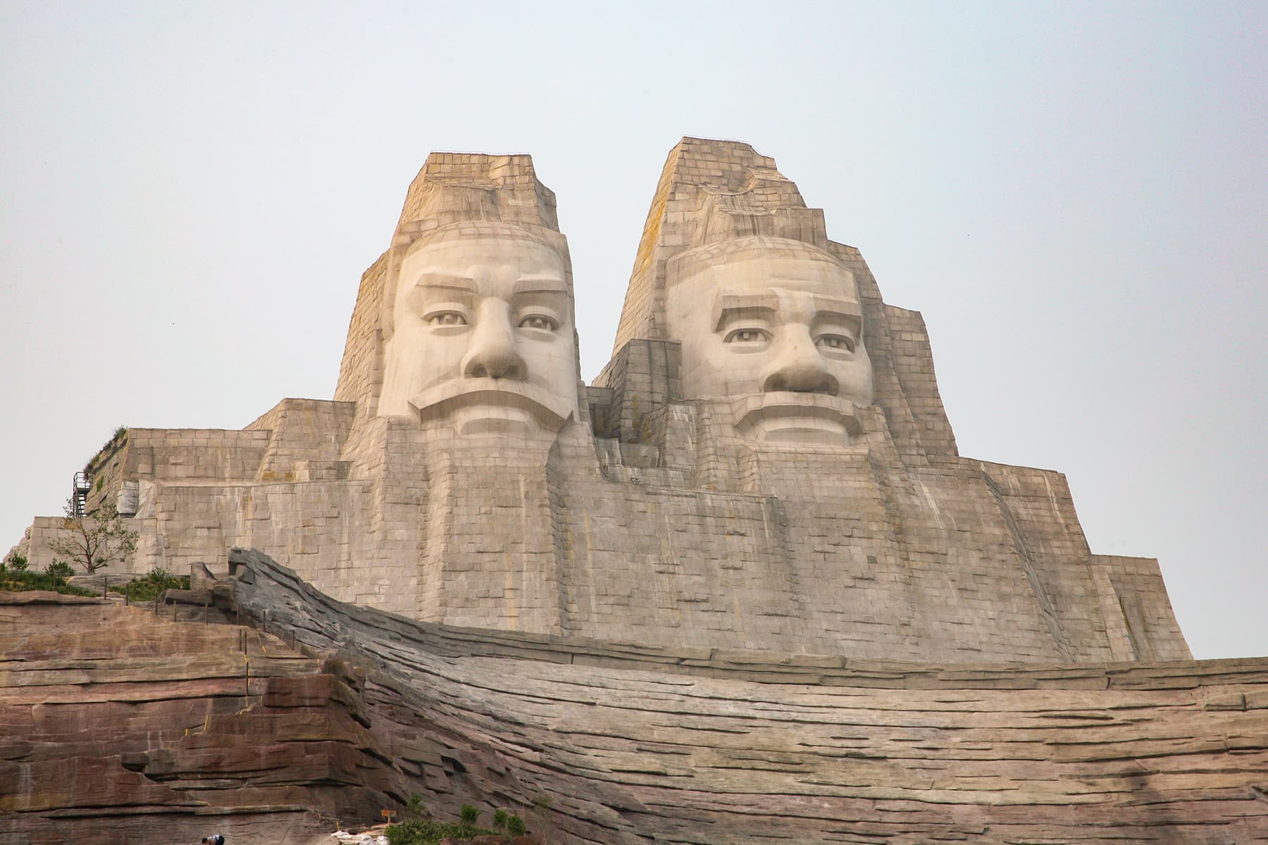 The 106-metre twin-figure sculpture of Emperors Yan and Huang looking out across the silt-brown Yellow River at the Yellow River Scenic Area, Zhengzhou