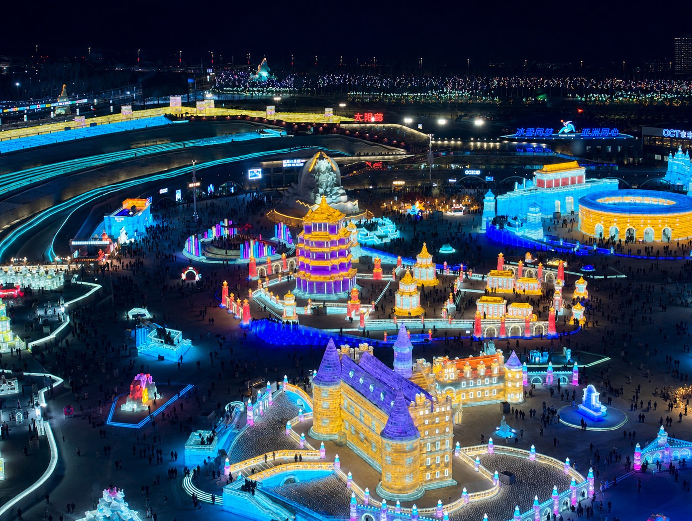 哈尔滨冰雪大世界一座手工雕琢的高大冰块，深红夜色自后方透出，刀凿之痕仍清晰留于冰面